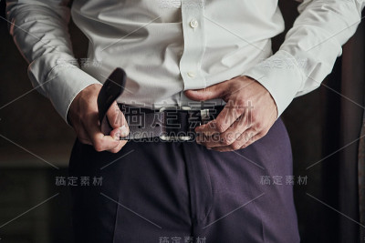 商人系上腰带，时尚穿衣理念，新郎在清晨前准备好仪式