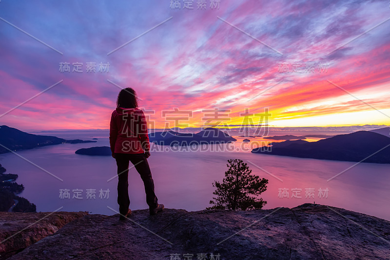 冒险的白人女孩站在山顶上