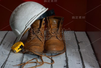 工作靴，白色建筑师头盔和米制胶带