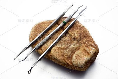 石头上的牙科工具。概念龋齿