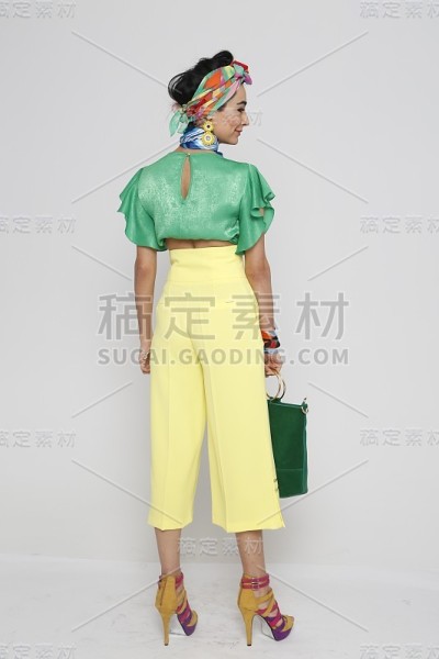 年轻美丽的女子在民族服装在绿色和黄色前面的白色背景。