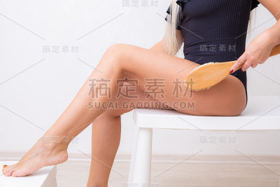 美丽的女性腿与瘦身按摩刷。身体护理和美容理念