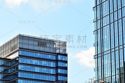 在蓝天的映衬下，商业区的现代摩天大楼