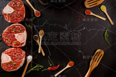 牛肉小腿和香料在黑色背景。