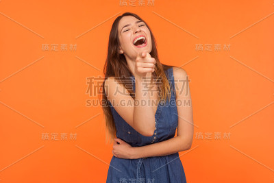 哈哈,嘿!兴奋快乐的黑发女人大声笑出来，抱着她的肚子和指向相机的手指