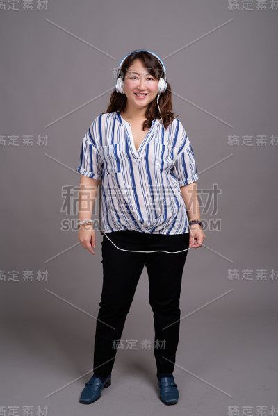 工作室拍摄的成熟美丽的亚洲女商人在灰色的背景
