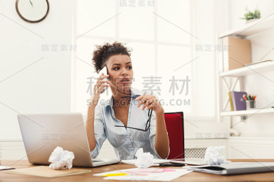 严肃愤怒的女商人在工作中打电话