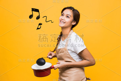 拿着锅和勺子的年轻女人。