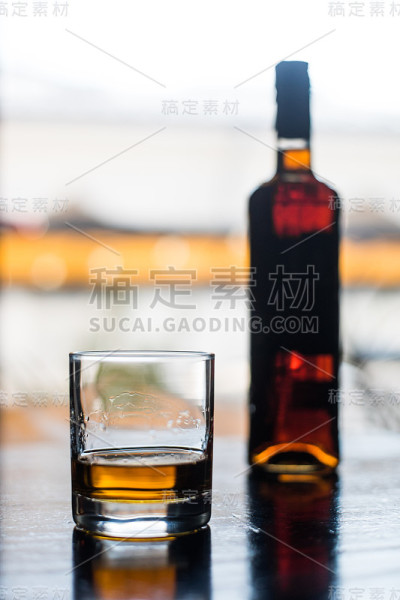 木质表面的威士忌酒杯和酒瓶