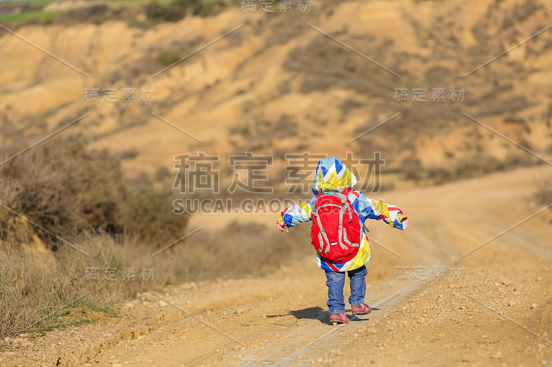 小女孩背着背包在路上旅行