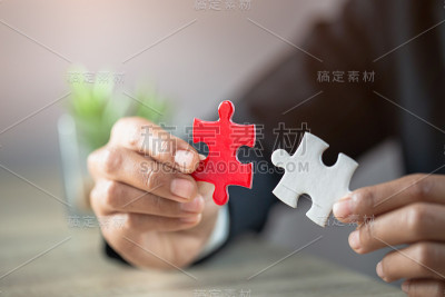 商业女性连接白色和红色拼图，合作的决策，团队支持解决问题和企业团队合作的概念。