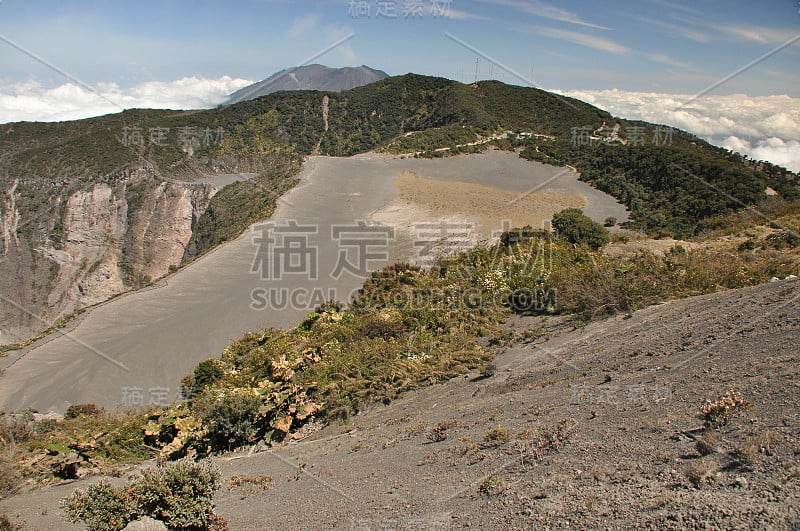 哥斯达黎加的伊拉祖火山。有防护屏障的云层中的火山口。熔岩和浮石的碎片。