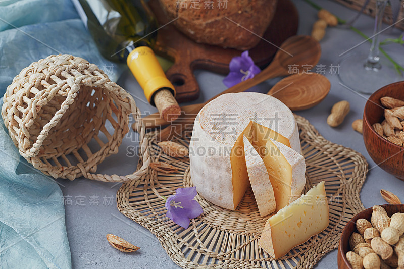 新鲜有机奶酪配面包、坚果、白葡萄酒和夏日鲜花。