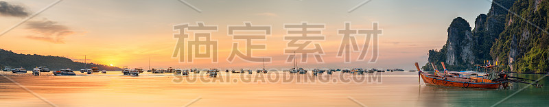 日落与色彩斑斓的天空和船在海滩上