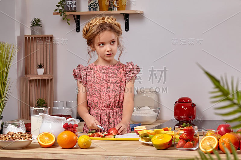 一个可爱的漂亮的女孩，有一个现代的发型，正在厨房里做饭的白色墙壁上的架子。