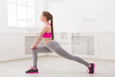 健身妇女伸展在室内的白色背景