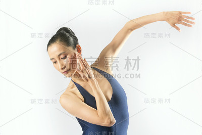 穿着蓝色紧身衣的成年女舞者在演播室跳舞。