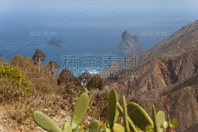 在阳光明媚的日子里，海岸线上有悬崖峭壁的火山景观