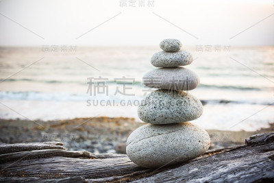 Inukshuk Cairn在海滩上的浮木上