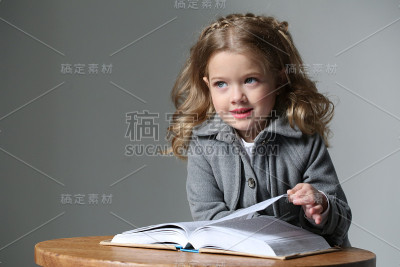 一个穿着大衣拿着书的孩子的肖像。近距离