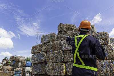 工程师和可回收材料。进行下一道工序的工程师工头戴着防护装备，拿着药片，看着可回收材料。
