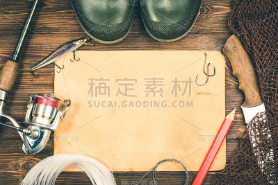 渔具-钓鱼，钓鱼，鱼钩和鱼饵，一张旧纸上的木制背景。健美的形象