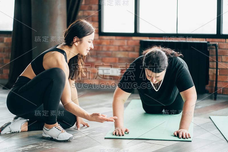 女性在私人教练的支持下锻炼