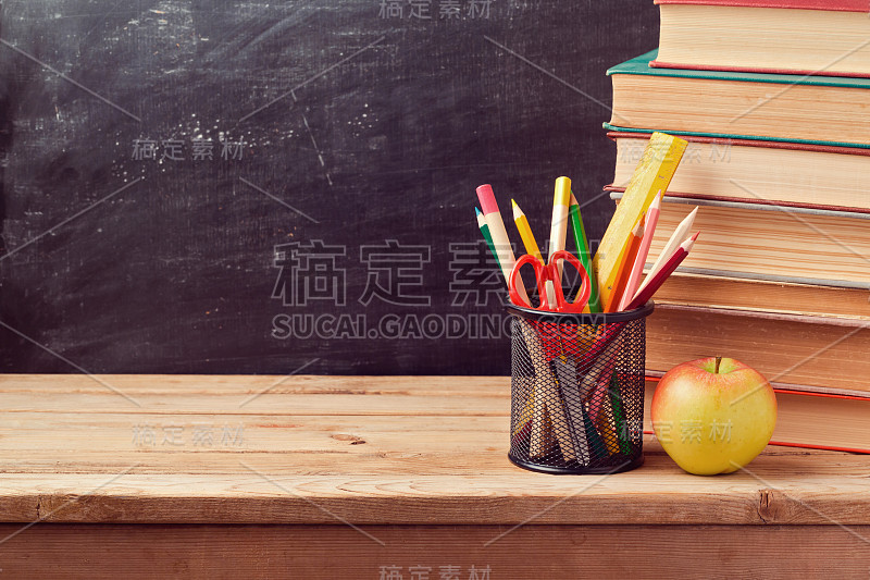 回到学校背景的书，铅笔和苹果在黑板上