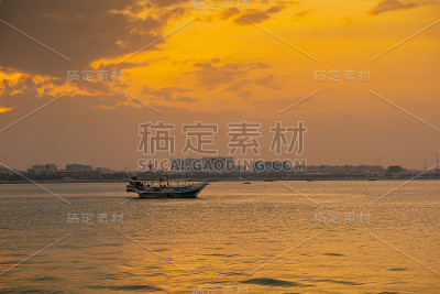 冬季的一天，多哈湾的美丽景色在日落与三角帆的背景