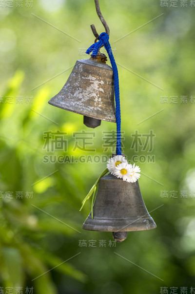 小金属东方钟挂在花园里，阳光明媚，绿树成荫