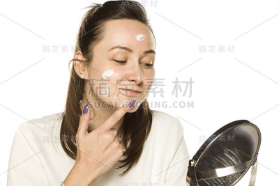 在白色背景上涂面霜的女人