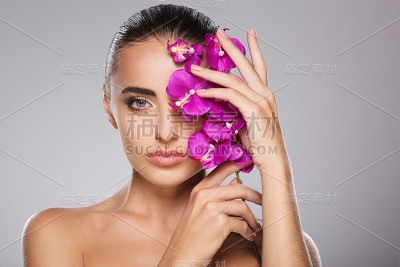 美丽的女孩与兰花闭上一只眼睛