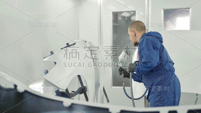 汽车喷漆工在专用展台的汽车备用挡泥板上喷涂白色油漆