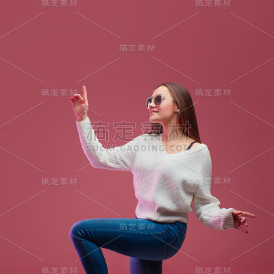 穿着牛仔裤和毛衣跳舞的有趣女学生。