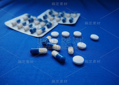 蓝色和白色，黄色的药片和药片在蓝色的纺织品背景。