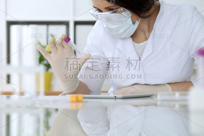 在实验室里用清晰的溶液观察科研人员的手