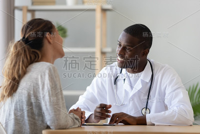 微笑的年轻女子访问非洲裔美国医生。