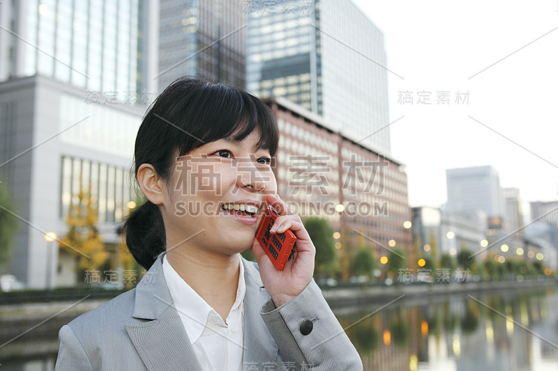 女商人在河边打手机日本人