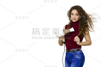 美丽快乐的少女干燥长棕色头发与一个吹风机在白色的背景
