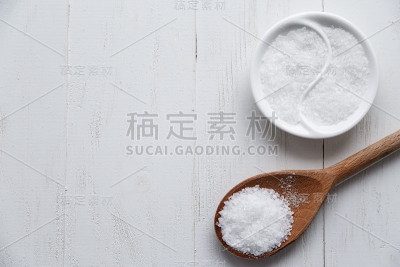 不同种类的盐。木勺上的黑色俯视图。本空间