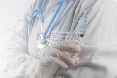 医生手持白色手套拿着注射器，用准备液喷射出针头。一名手持注射器的医务人员。外科医生手持疫苗。注射流感