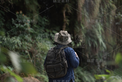 徒步旅行者在大自然美丽的热带雨林中旅行。年轻的亚洲人踏上了穿越森林的旅程。