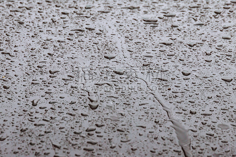 水滴在车上。背景。小雨打在金属。