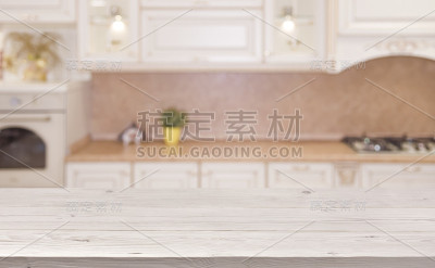 模糊的厨房内部背景与木板桌子在前面