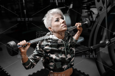 金发性感的运动年轻女孩在健身房锻炼
