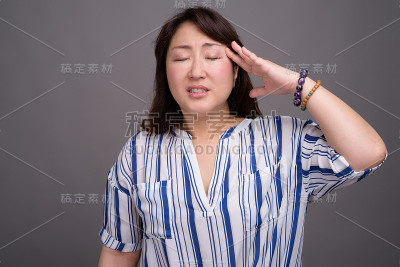 工作室拍摄的成熟美丽的亚洲女商人在灰色的背景