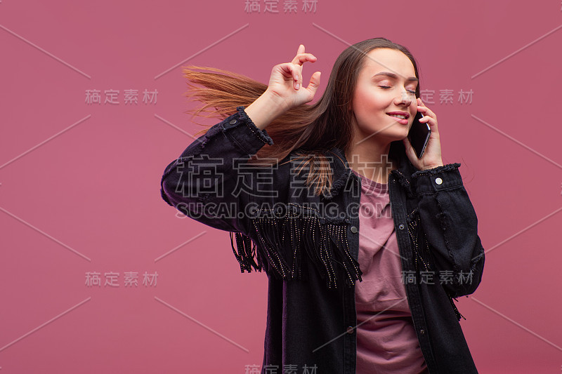 一位心情愉快、面带微笑的年轻黑发女子在用智能手机，