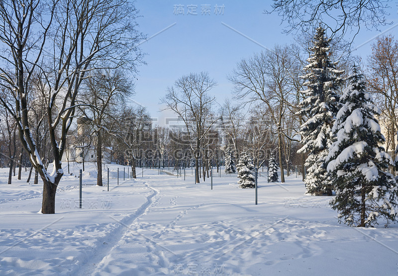 白雪皑皑的冬季公园，背景是古老的教堂，俄罗斯普斯科夫