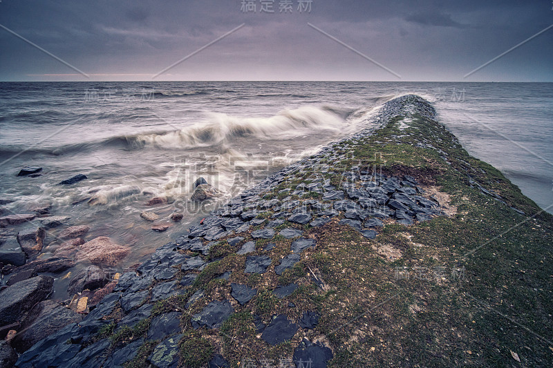 有暴风雨的天气，湖面上有乌云，海岸线上有暴风雨的波涛