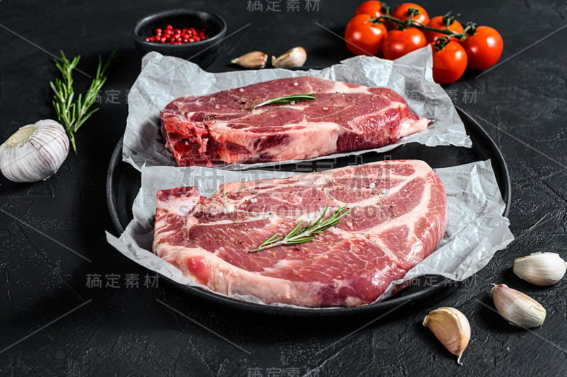 生猪肉牛排。仿羊皮纸上的大理石肉。黑色背景。俯视图